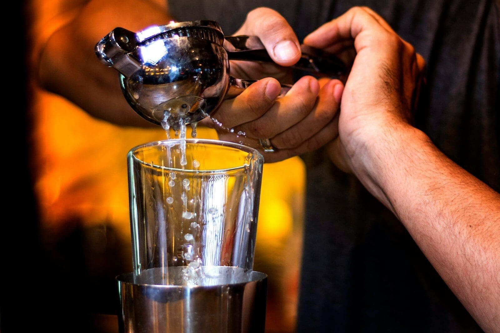 person pouring water on clear drinking glass